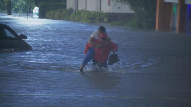 El momento en que un reportero rescata a una mujer atrapada en su carro durante una inundación